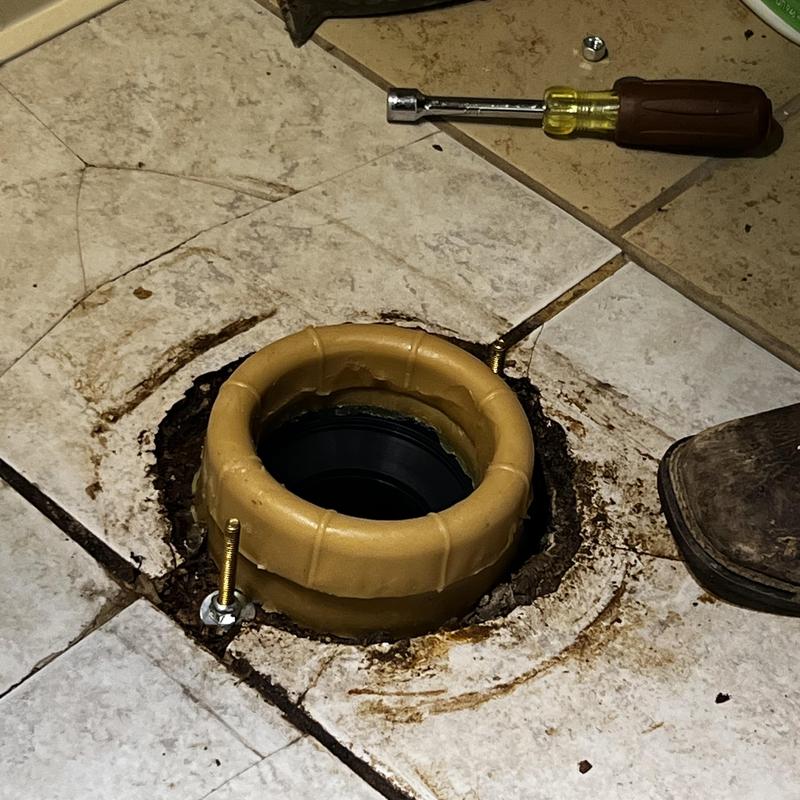 Toilet flange with new bolts on tiled floor Toilet flange with new bolts on tiled floor