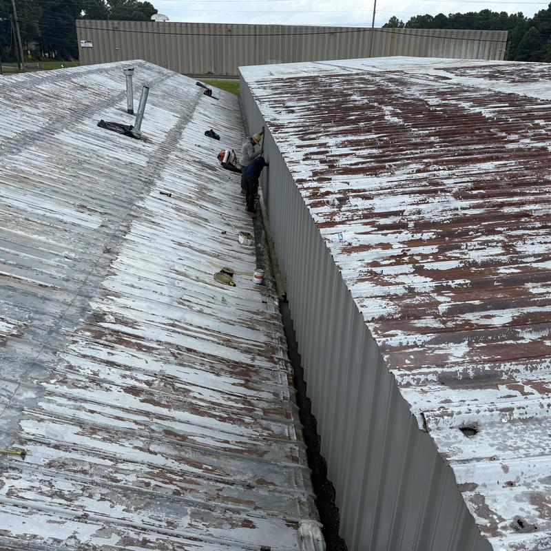 Industrial metal roof with rust remediation in progress Industrial metal roof with rust remediation in progress