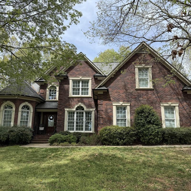 Roof shingles on brick house with trees and lawn Roof shingles on brick house with trees and lawn