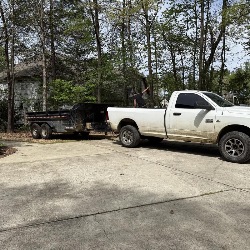 Dump trailer attached to white pickup truck outdoors Dump trailer attached to white pickup truck outdoors