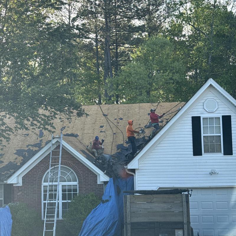Roof sheathing exposure during asphalt shingle removal in Loganville