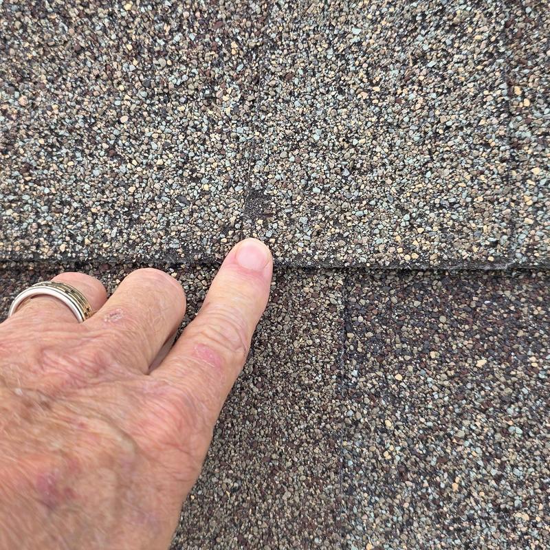 Asphalt shingle roof with hail impact damage close-up