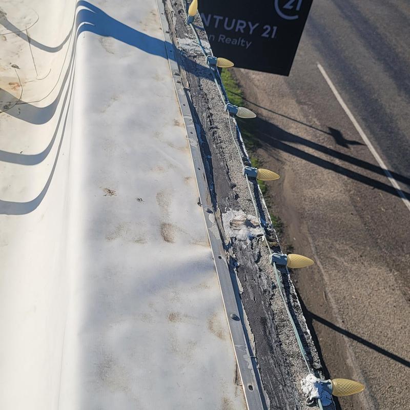 Flat commercial roof edge with string lights installation