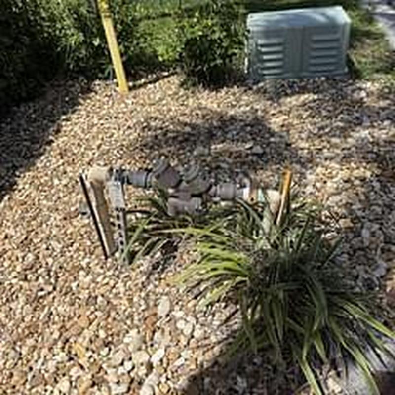 Backflow prevention device surrounded by landscaping rocks