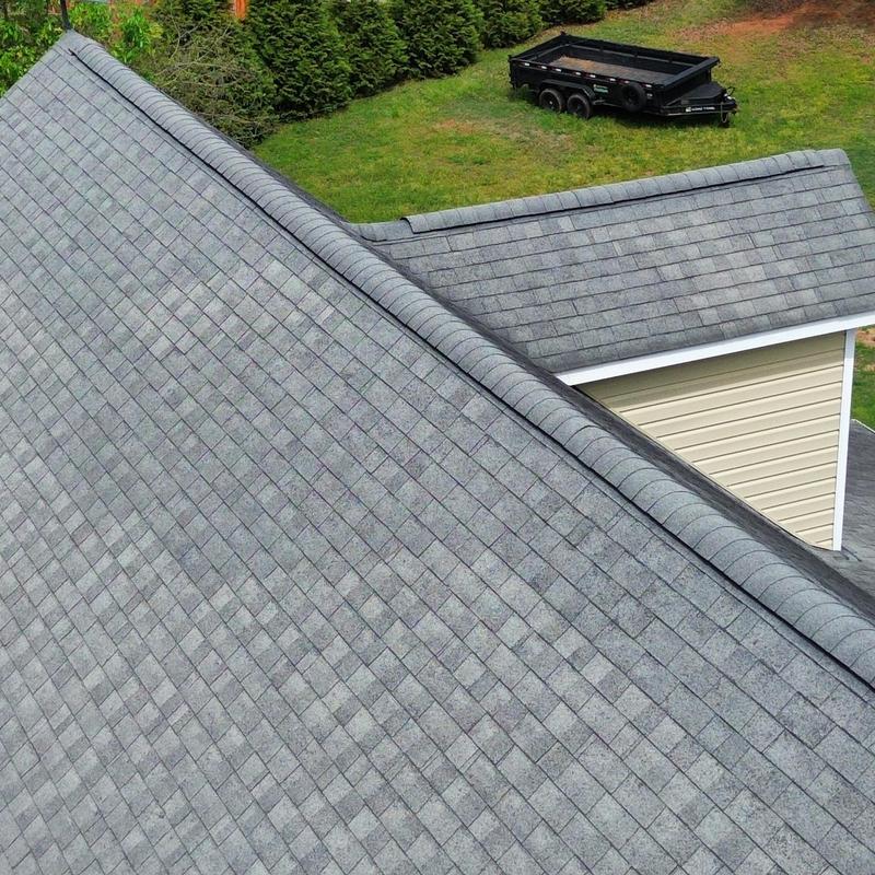 Grey asphalt shingle roof with ridge caps and gutters