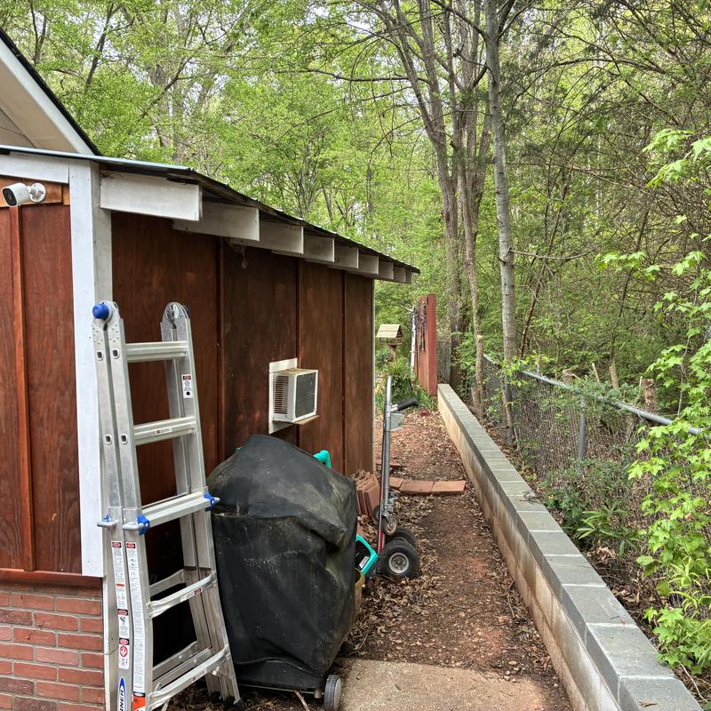 Retaining wall beside wood shed and walkway