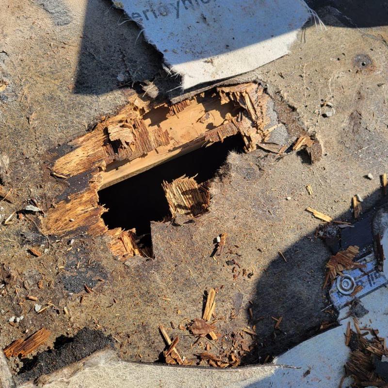 Roof decking with water damage hole near solar vent