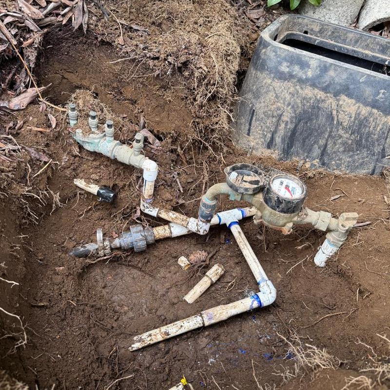Underground water meter and piping exposed for repair