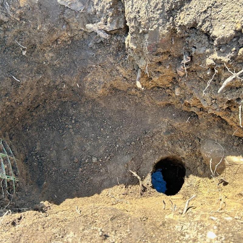 Main line sewer pipe excavation hole in soil Main line sewer pipe excavation hole in soil