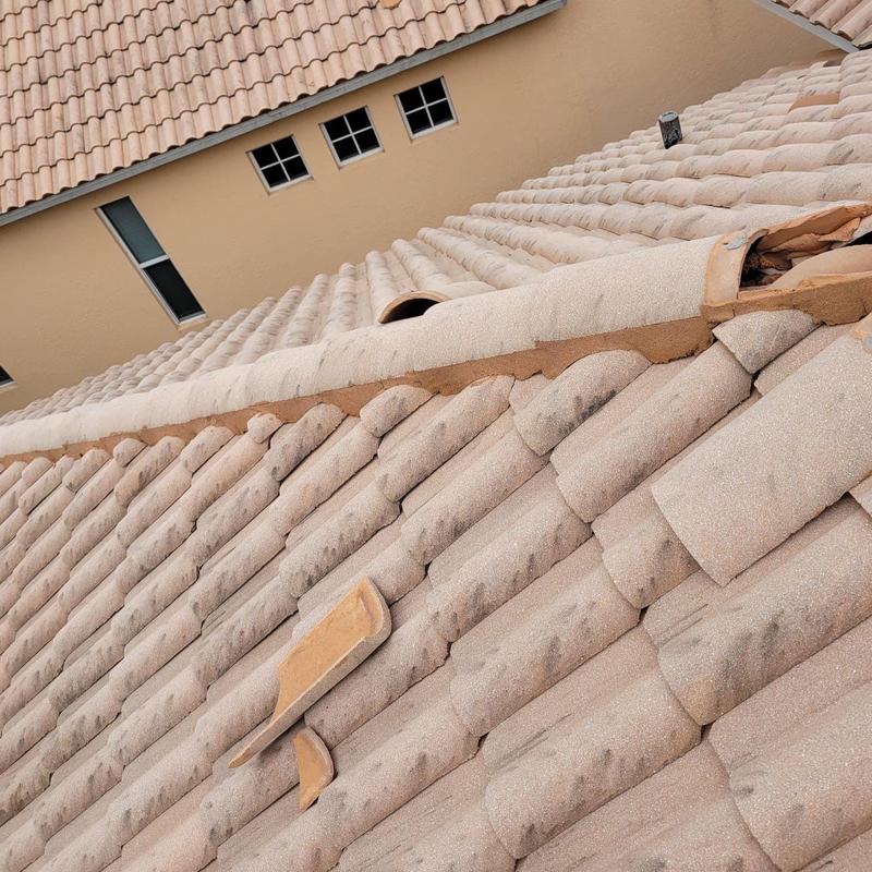 Concrete tile roof with broken and displaced tiles and failing mortar