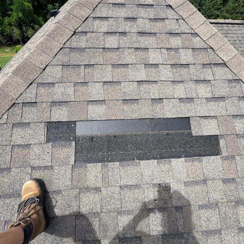 Asphalt shingle roof with patched hail damage and granule loss