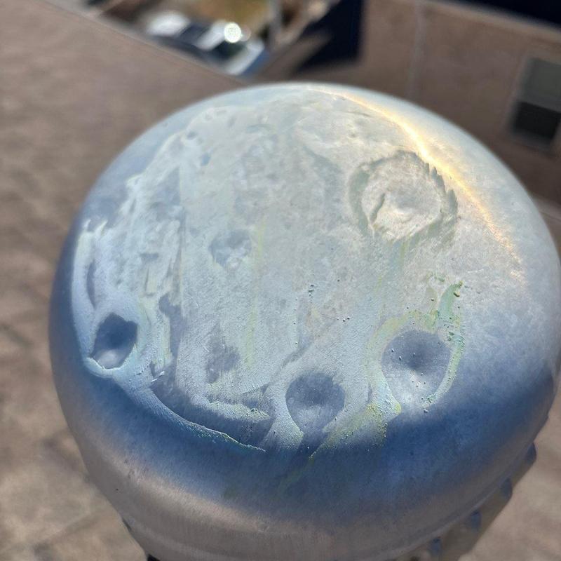 Metal roof vent cap with hail damage dents and marks