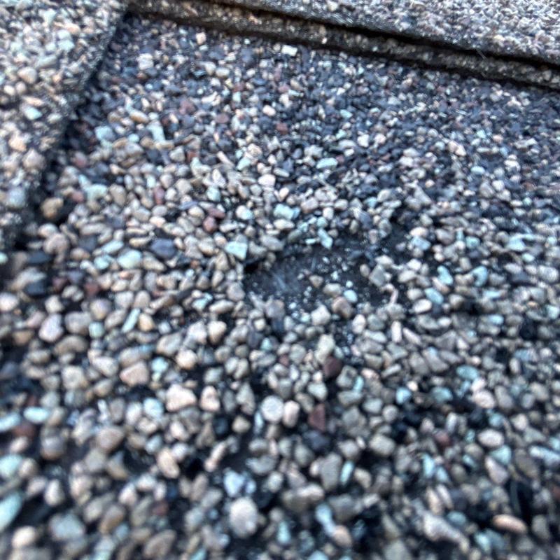 Asphalt shingle granule loss from hail damage close-up