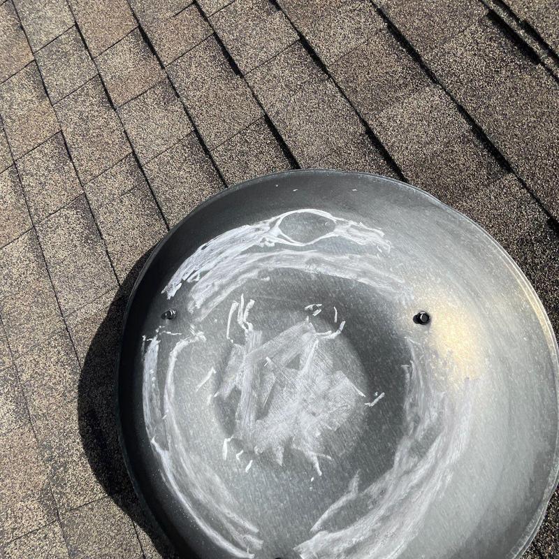 Roof vent with hail damage markings on shingles
