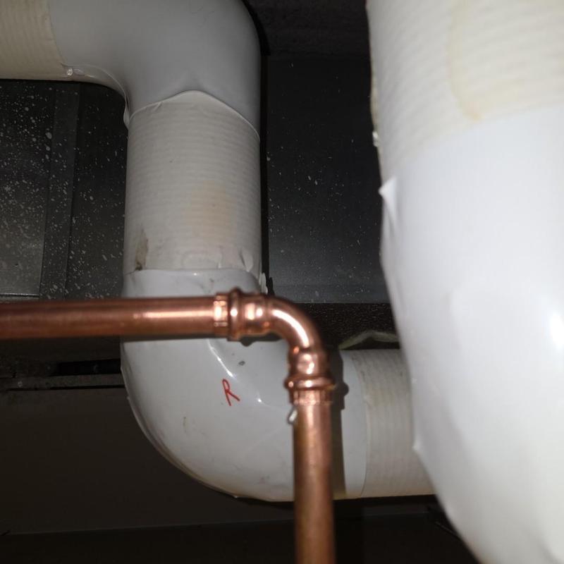 Copper refrigerant line near insulated pipe in lobby
