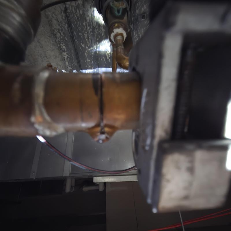 Copper refrigerant line with pinhole leak in HVAC system