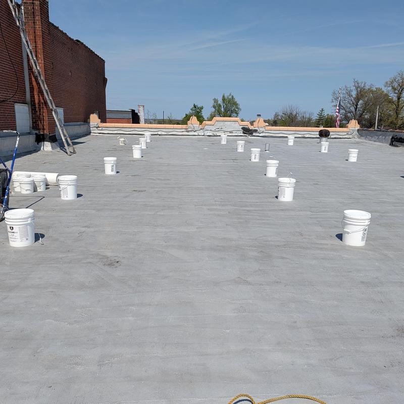 Elastomeric coating buckets on flat commercial roof