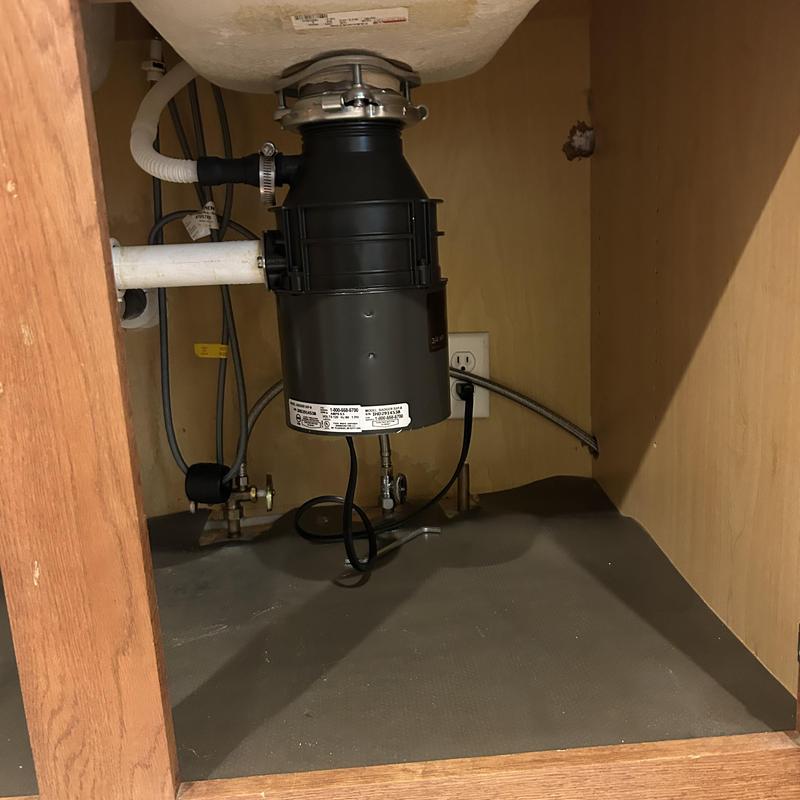 Garbage disposal unit under kitchen sink with pipes Garbage disposal unit under kitchen sink with pipes