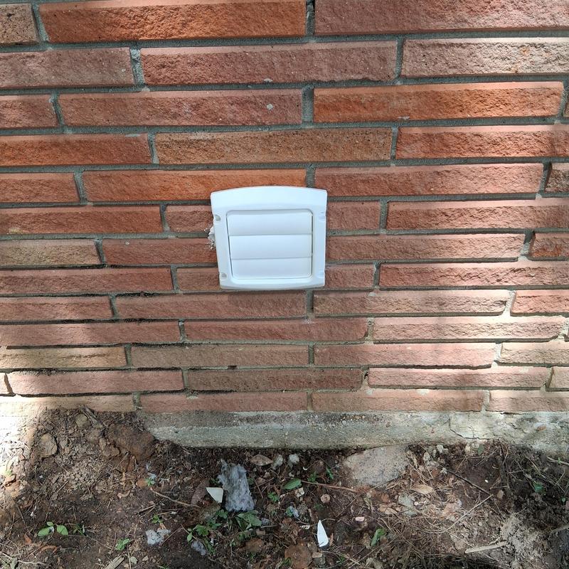 Dryer vent through brick wall with white cover