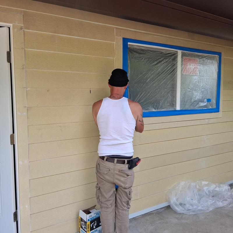 Exterior wall siding and window prepped for painting