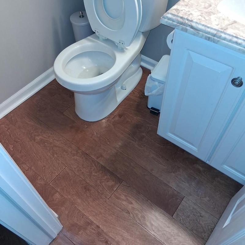 Toilet bowl with open lid in bathroom corner