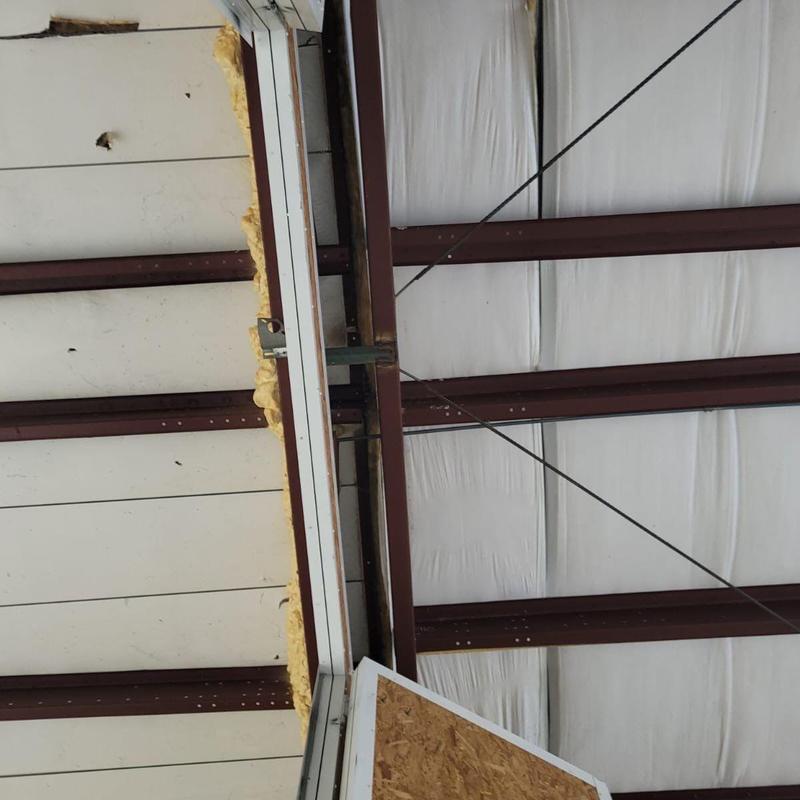 Metal roof interior with insulation and damaged panels
