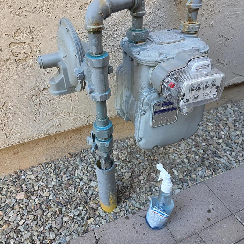 Gas meter and pipeline with leak test spray applied
