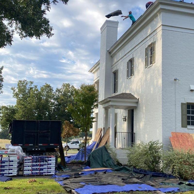 Asphalt roof shingles being tossed down from roof Asphalt roof shingles being tossed down from roof