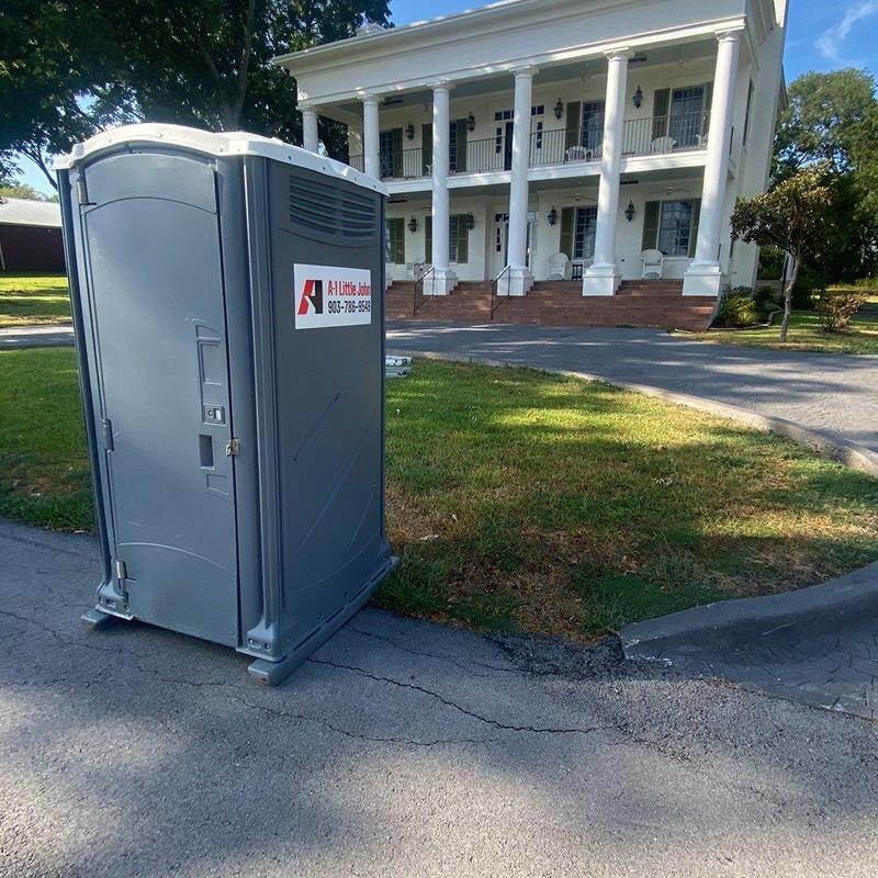 Portable restroom on property driveway near historic house Portable restroom on property driveway near historic house