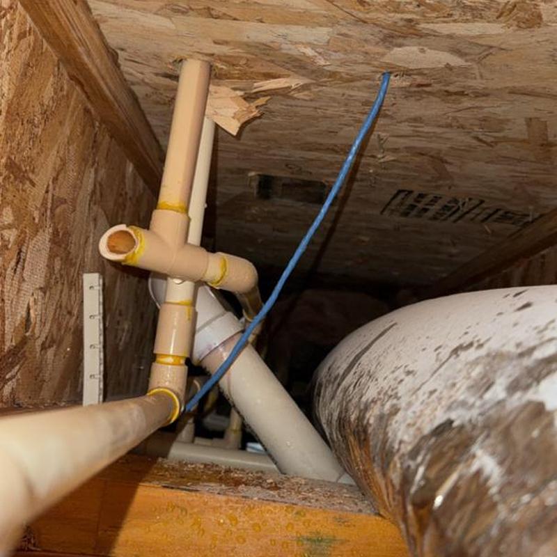 PVC pipe with yellowed joints in crawl space
