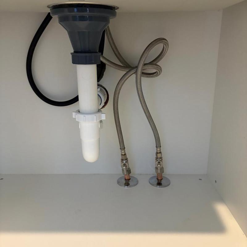 Sink drain and water supply lines under cabinet