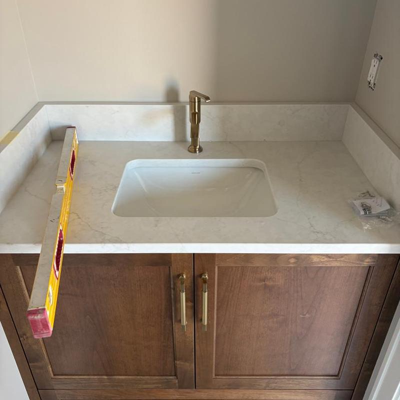 Bathroom sink with brass faucet and marble countertop