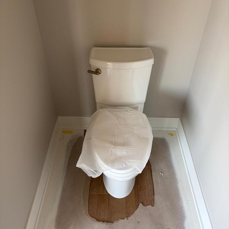 Toilet installation with protective seat cover in small room