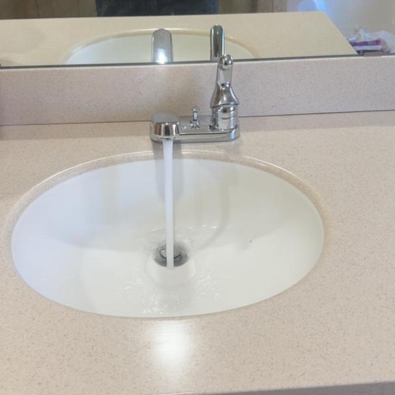 Delta lavatory faucet with running water on countertop
