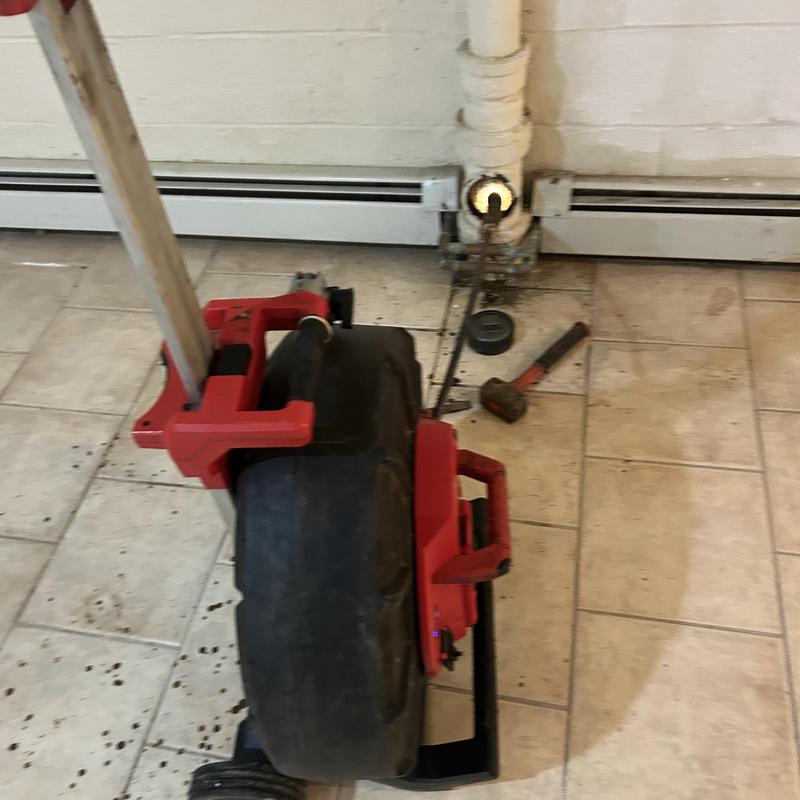 Drain cleaning machine with pipe access in basement Drain cleaning machine with pipe access in basement