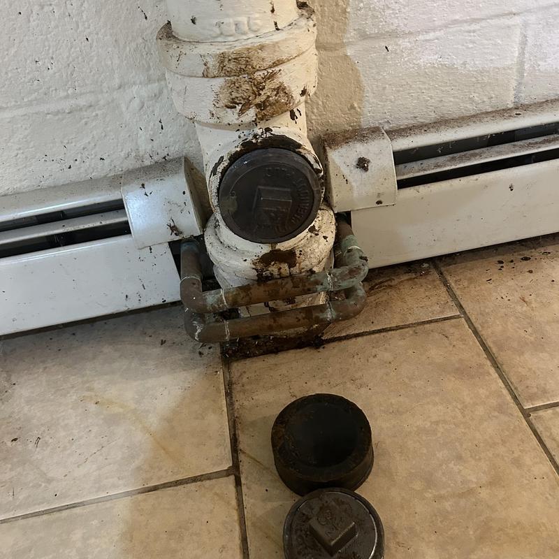 Cast iron cleanout with removed caps and rust stains Cast iron cleanout with removed caps and rust stains