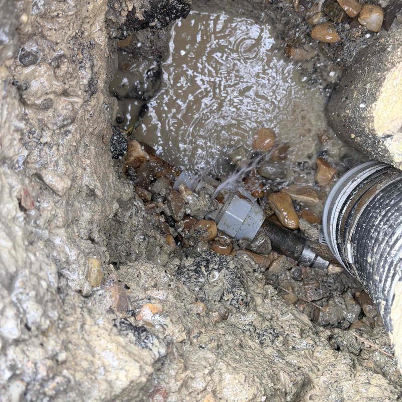 Outdoor water line leak with hose connection in muddy hole
