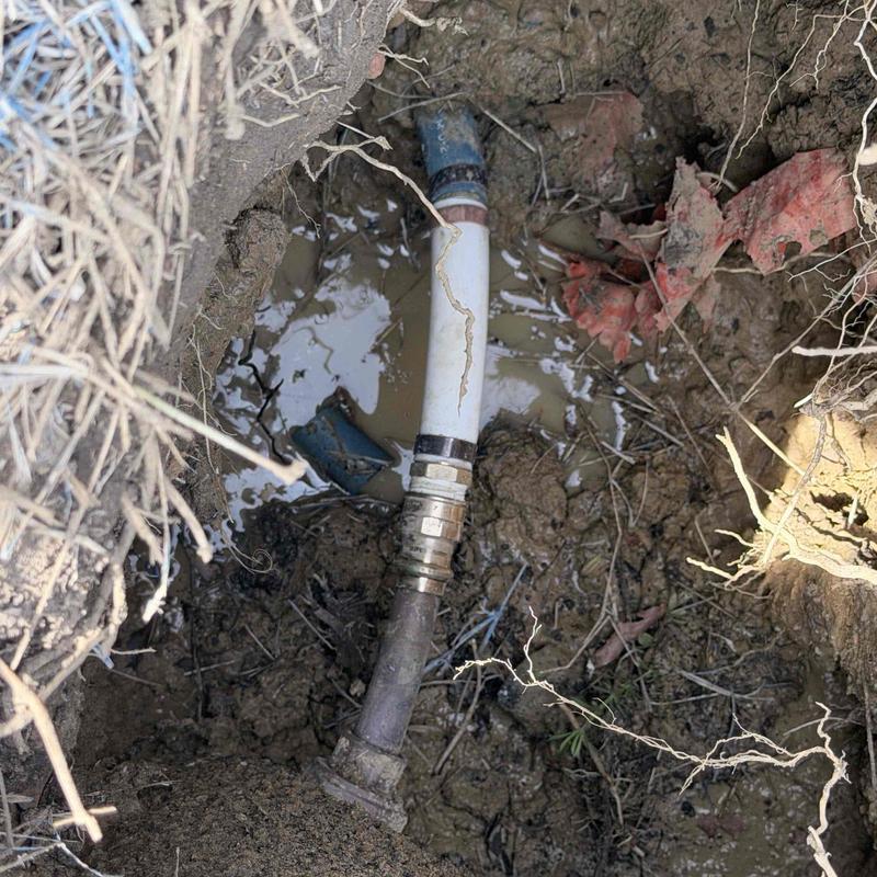 Water line pipe with fittings in muddy excavation
