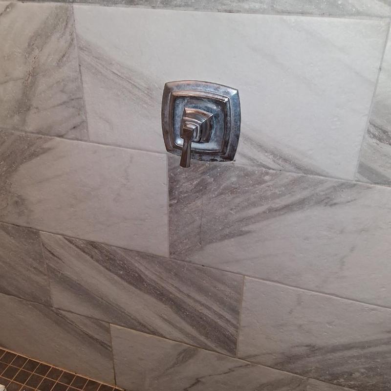 Moen shower valve handle with tile wall background
