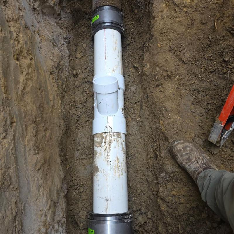 6-inch sewer pipe installation in trench with tools