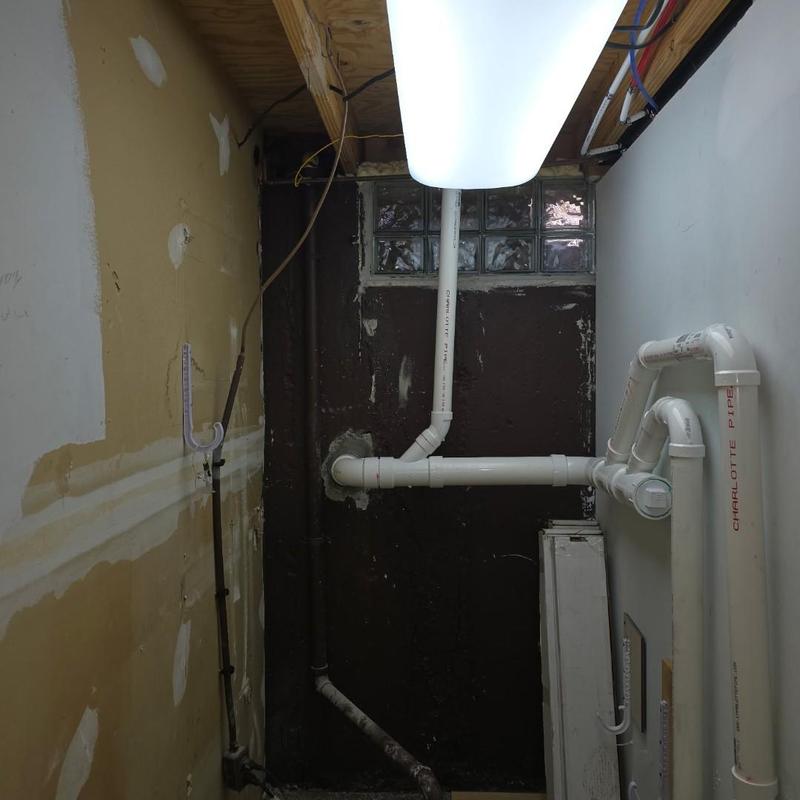 Sewer line rerouted with PVC pipe in closet