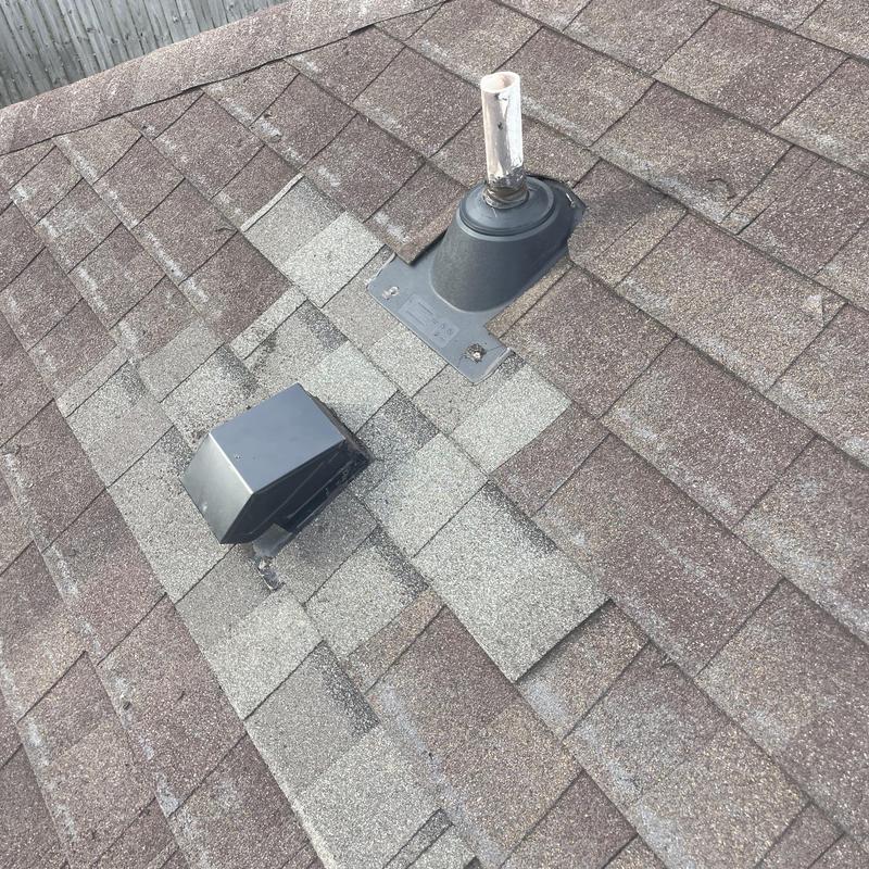Roof vent flashing with replaced shingles on asphalt roof