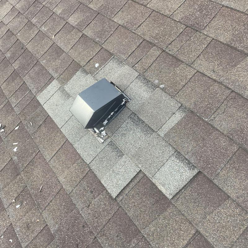 Roof vent flashing with replaced shingles on asphalt roof