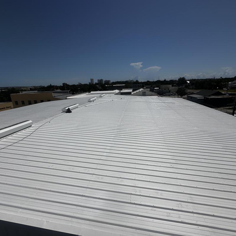 Metal roof with white reflective acrylic coating under clear sky Metal roof with white reflective acrylic coating under clear sky