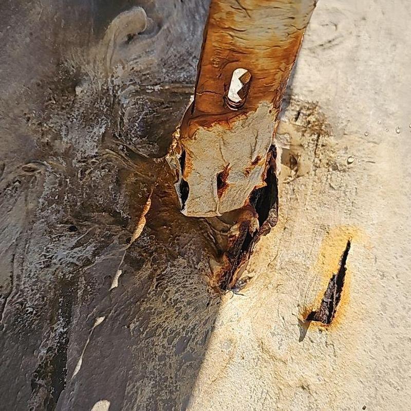 Rust-damaged metal roof screw and panel corrosion