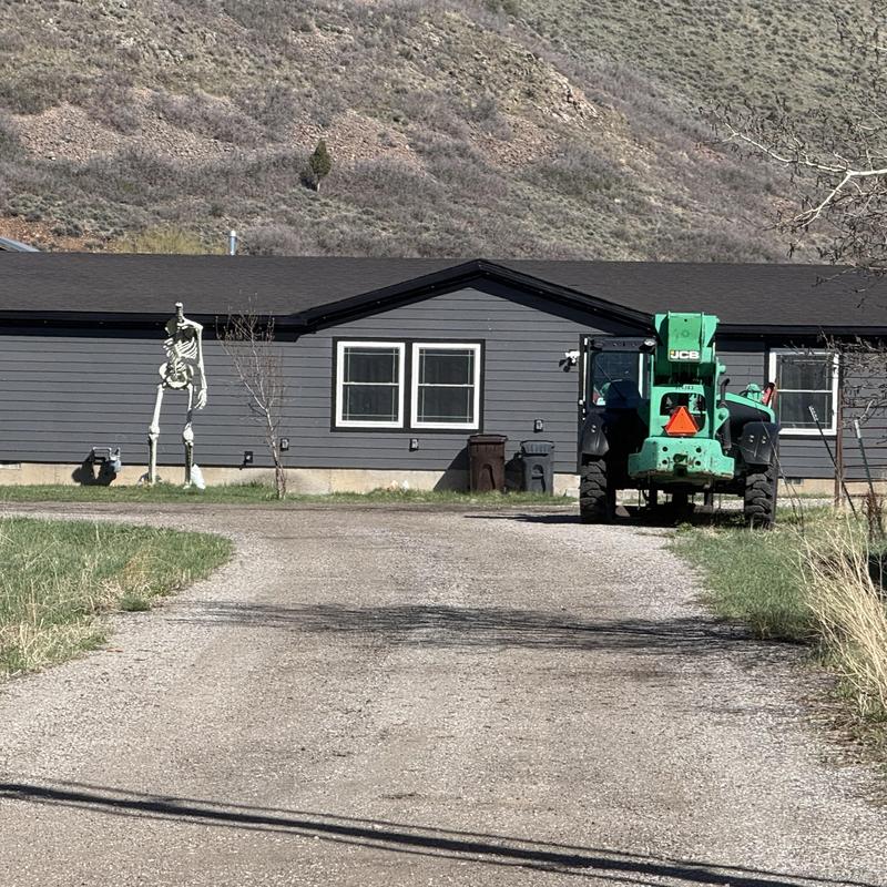 Asphalt shingle roof on rural house with construction lift