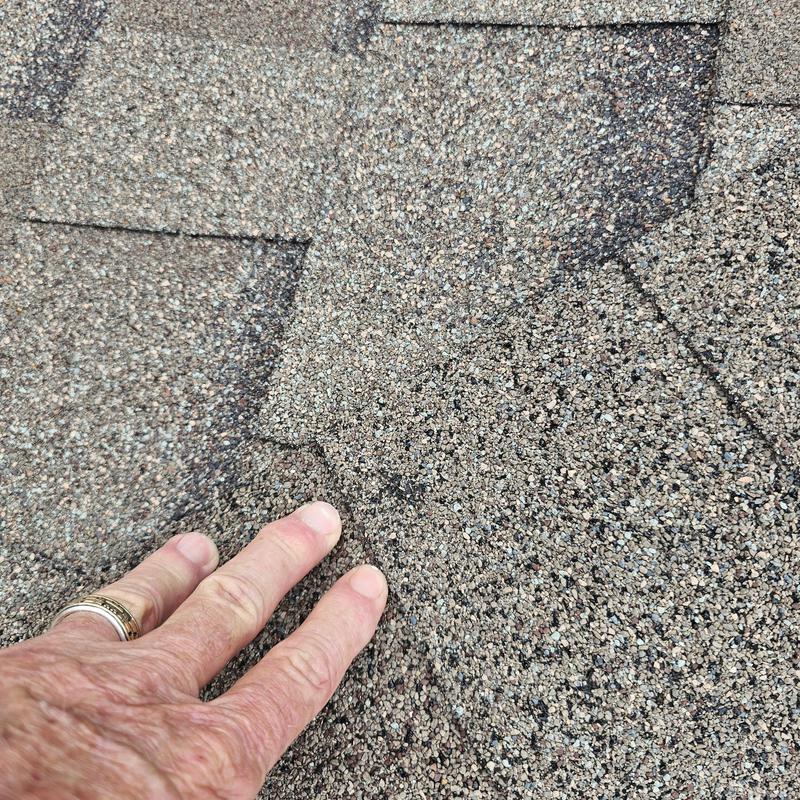 Asphalt roof shingles showing hail damage close-up