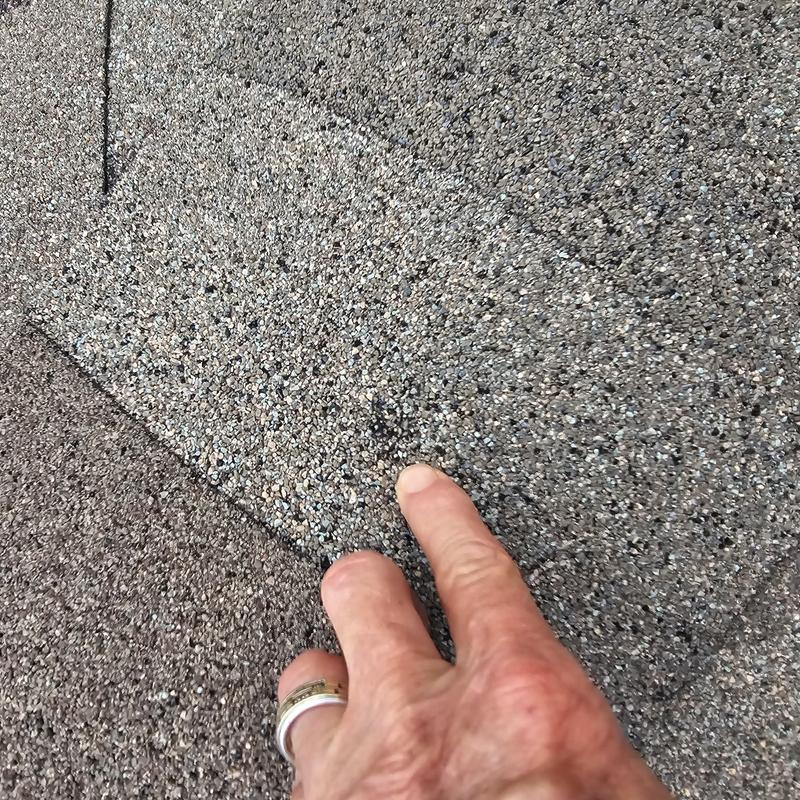Asphalt shingle roof with hail damage close-up inspection