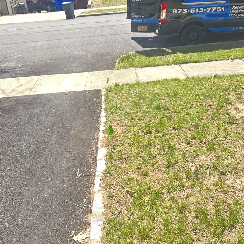 Sewer cleanout cap with utility flags by driveway Sewer cleanout cap with utility flags by driveway