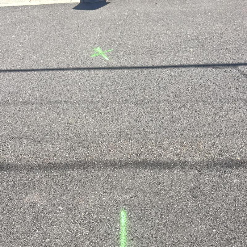 Sewer line underground location markings on asphalt driveway Sewer line underground location markings on asphalt driveway